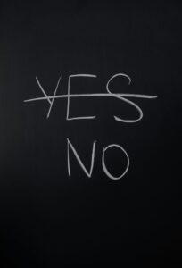 Handwritten chalk decision concept with 'yes' crossed out and 'no' emphasized.