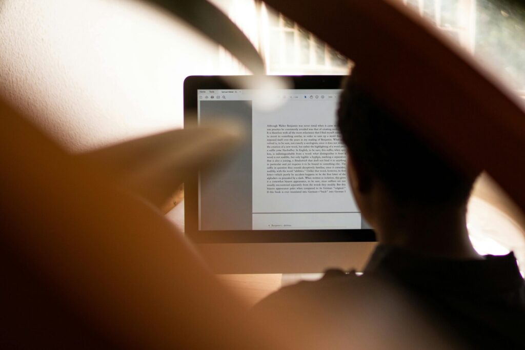 Silhouette of a person working from home on a computer, highlighting remote work lifestyle.