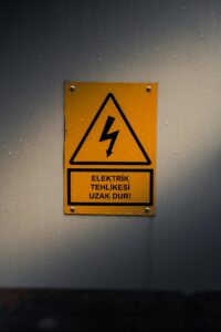Yellow warning sign indicating electrical danger. Turkish text warns to stay away.