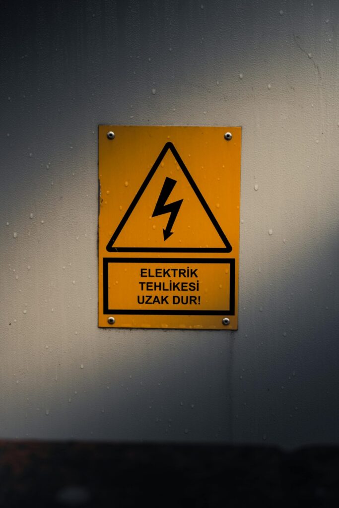 Yellow warning sign indicating electrical danger. Turkish text warns to stay away.