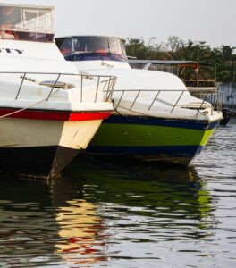Two docked boats reflecting on calm water during sunset. Tranquil scene showcasing waterfront leisure.